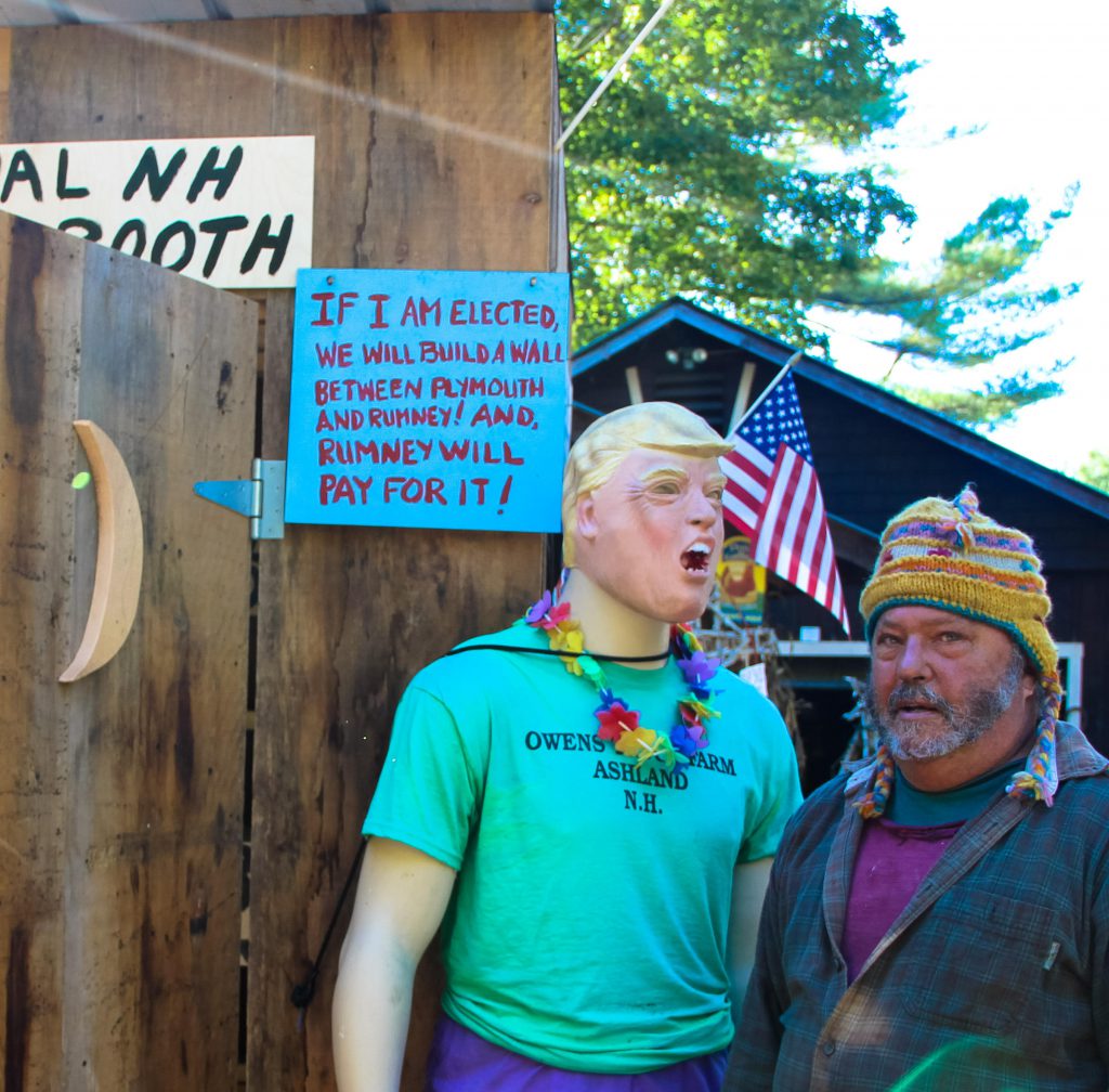 Chris Owens poses with a Donald Trump mannequin outside of his outhouse.