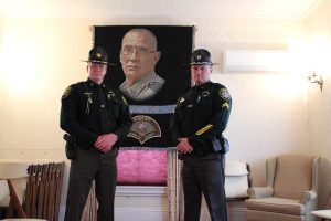 Two officers from the Sagadahoc County Police Department, watching over the casket of Eugene Cole at the Smart and Edwards Funeral Home in Skowhegan. Photo by Robbie Feinberg for Maine Public