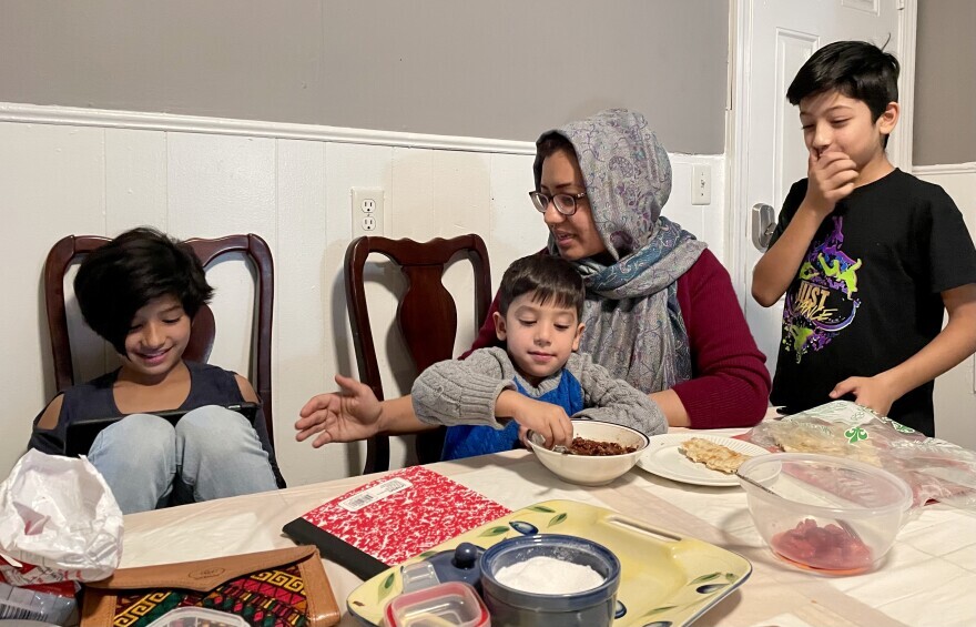 Farkhanda Ehssan gathers her three children around the dinner table at their new home in New Bedford, Mass.