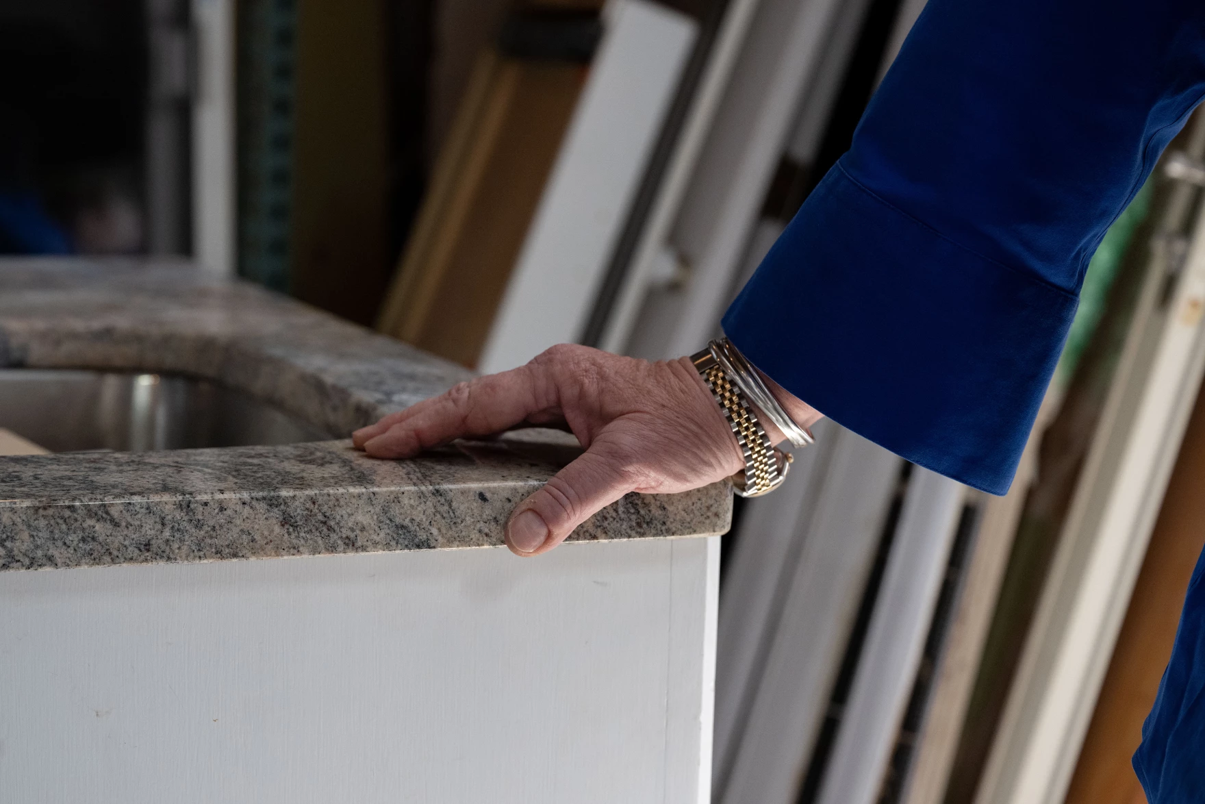 A closeup of WasteNot co-owner Ann Jarosiewicz's hand as she leans on a salvaged stone countertop.