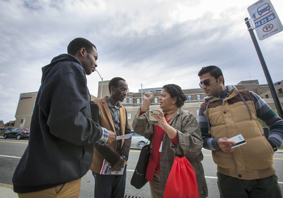 Ascentria Care Alliance, a resettlement agency based in Worcester, announced Monday that as a result of Trump's travel ban it had laid off or reduced hours for 14 employees. In this 2015 photo, an Ascentria instructor shows clients when the next WRTA bus will arrive using a smartphone app. Photo by Jesse Costa for WBUR